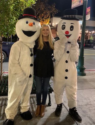 woman between snowmen on street
